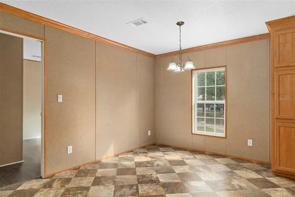 a view of an empty room with windows and entryway