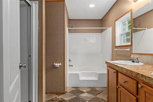 a bathroom with a granite countertop sink a toilet and shower