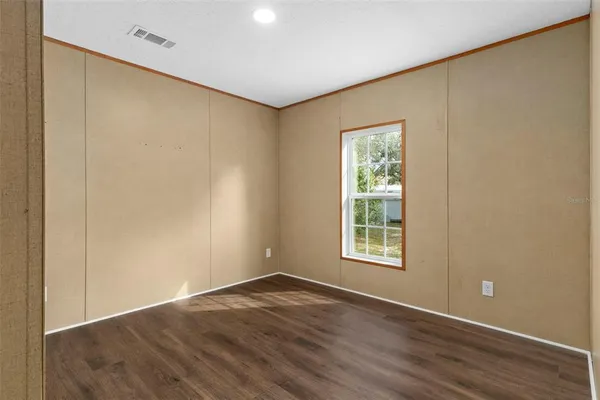 an empty room with wooden floor and closet