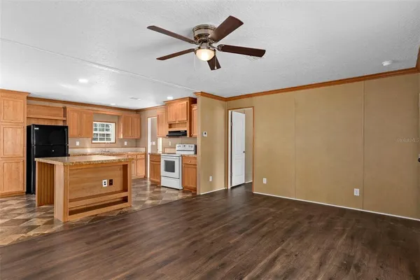 a living room with wooden floors and kitchen view