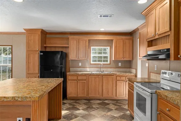 a kitchen with stainless steel appliances granite countertop a sink stove and refrigerator