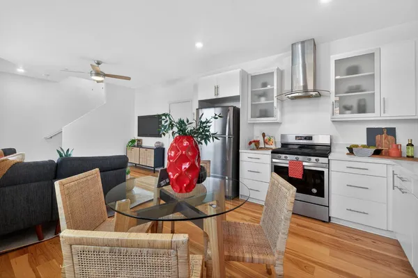 a kitchen with stainless steel appliances kitchen island granite countertop a refrigerator and cabinets