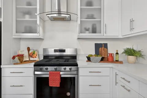 a kitchen with stainless steel appliances granite countertop white cabinets and a stove