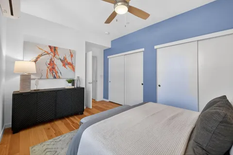 a bedroom with bed and a painting on the wall