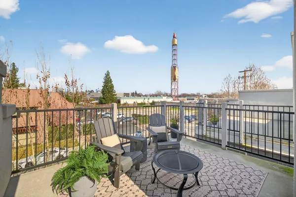a view of a balcony with chairs and iron fence