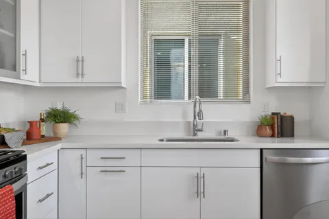 a kitchen with stainless steel appliances white cabinets and a sink