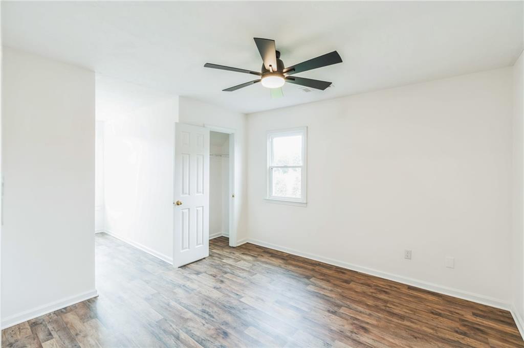 500 Coleman Mill Road Carrollton, GA 30116 - Photo 35 of 83 an empty room with wooden floor a ceiling fan and windows
