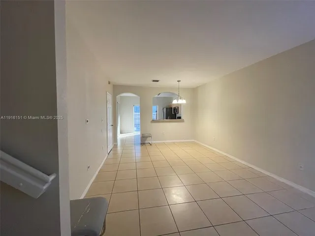 a view of a hallway with wooden floor and a living room