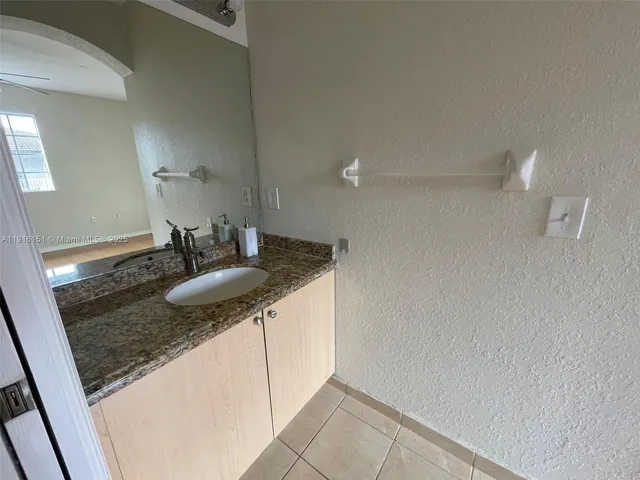 a bathroom with a granite countertop sink and a mirror