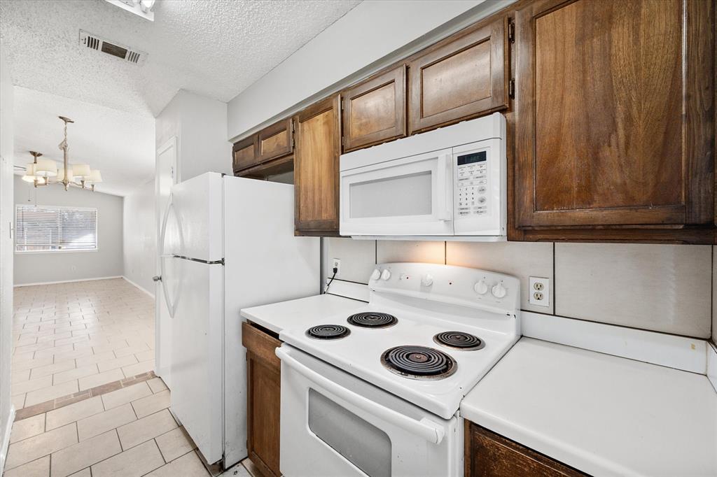 5821 Mansfield Road Arlington, TX 76017 - Photo 11 of 24 a kitchen with a refrigerator and a stove top oven