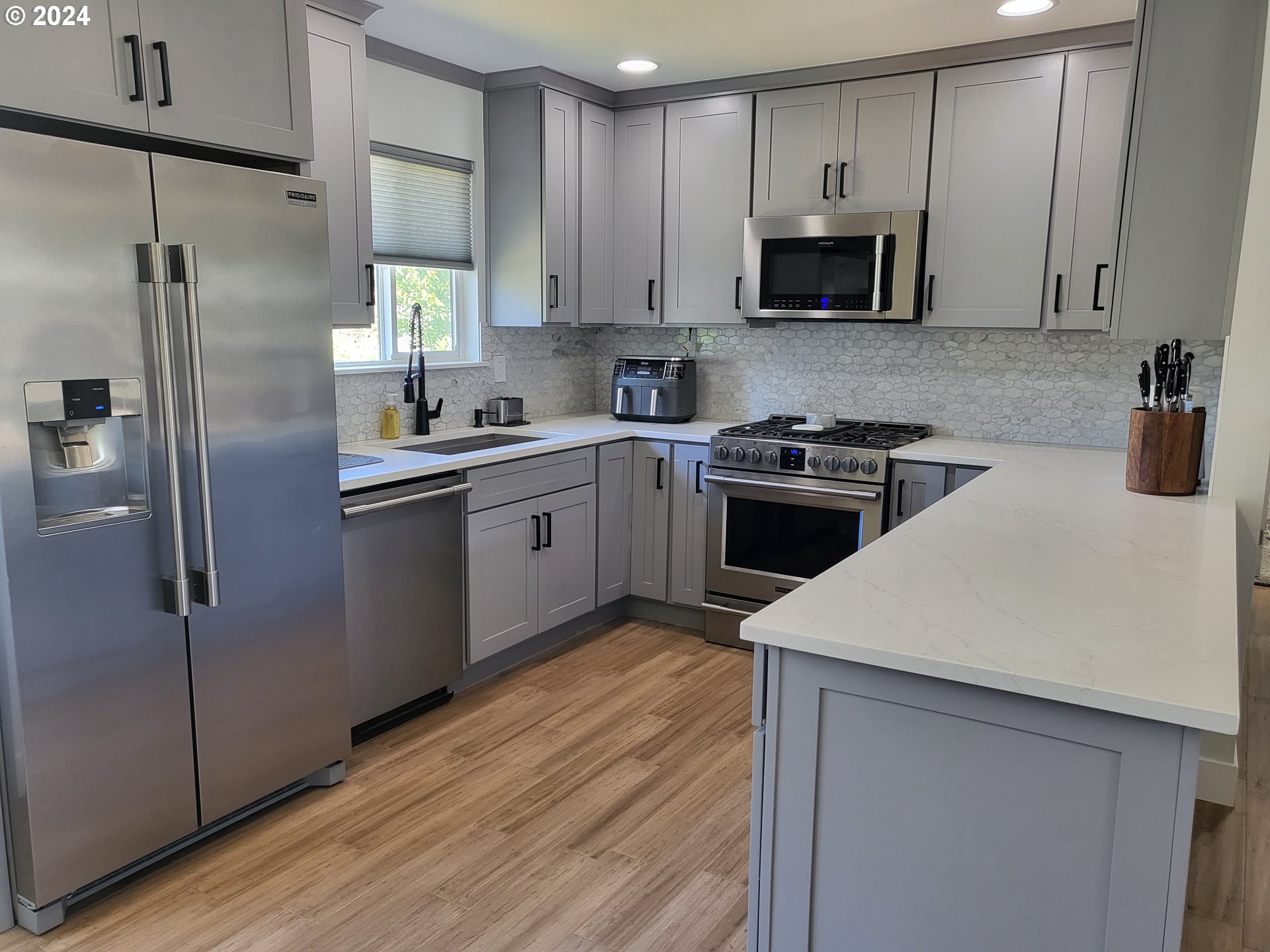949 Southeast 221st Avenue Gresham, OR 97030 - Photo 4 of 19 a kitchen with stainless steel appliances granite countertop a stove a sink and a refrigerator