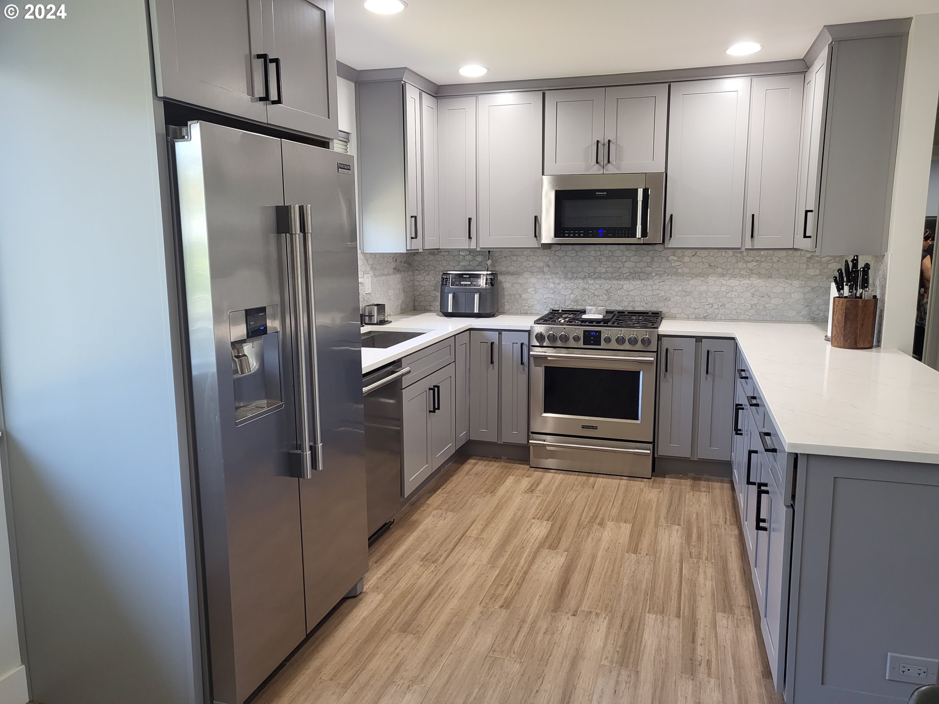 949 Southeast 221st Avenue Gresham, OR 97030 - Photo 5 of 19 a kitchen with stainless steel appliances granite countertop a refrigerator stove and sink