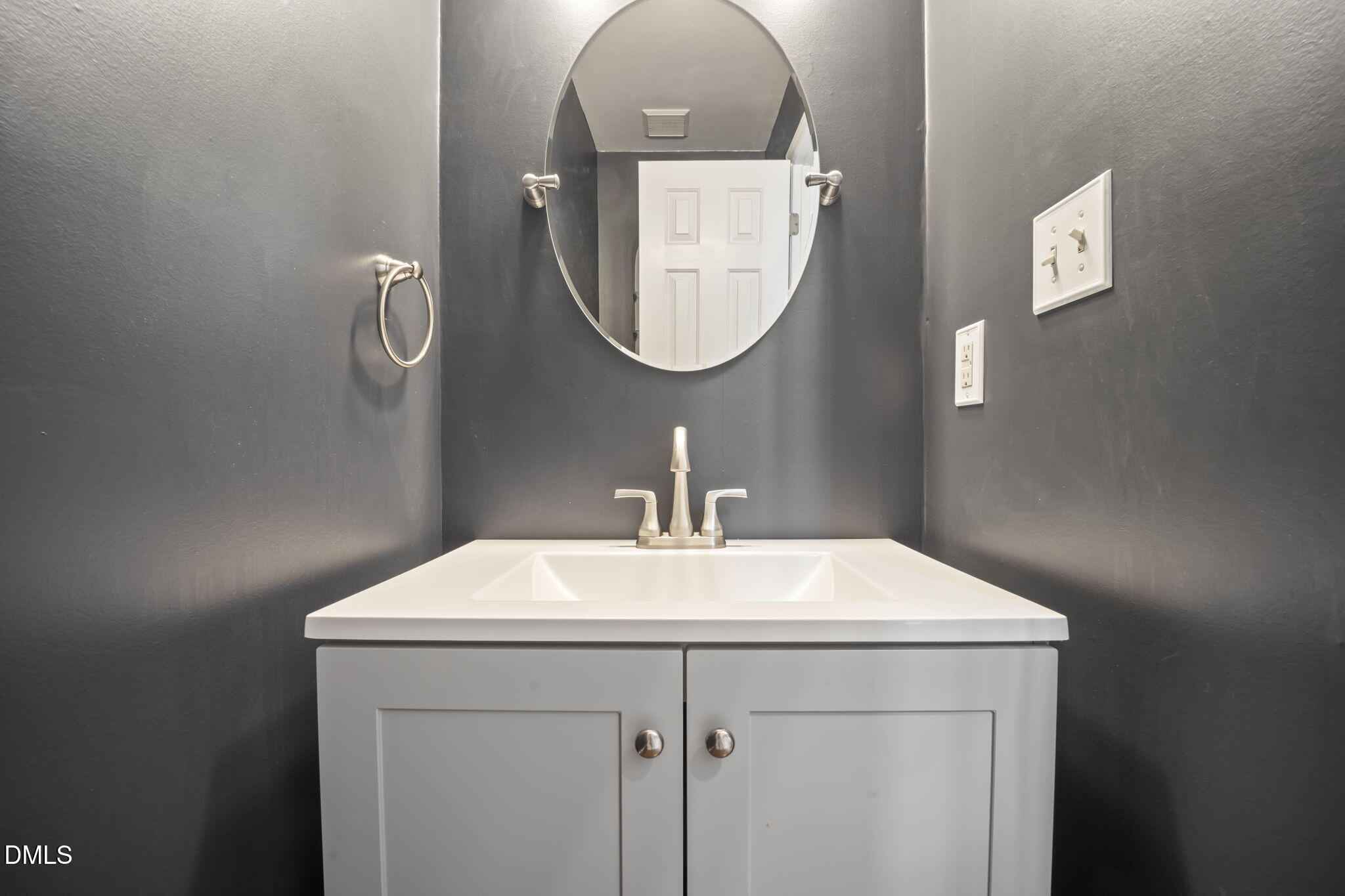 8665 Harps Mill Road Raleigh, NC 27615 - Photo 14 of 36 a bathroom with a sink a mirror and vanity