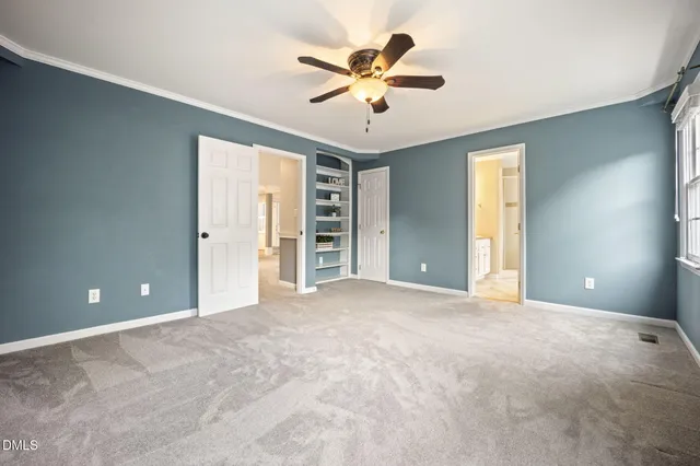 a view of an empty room with a ceiling fan and window