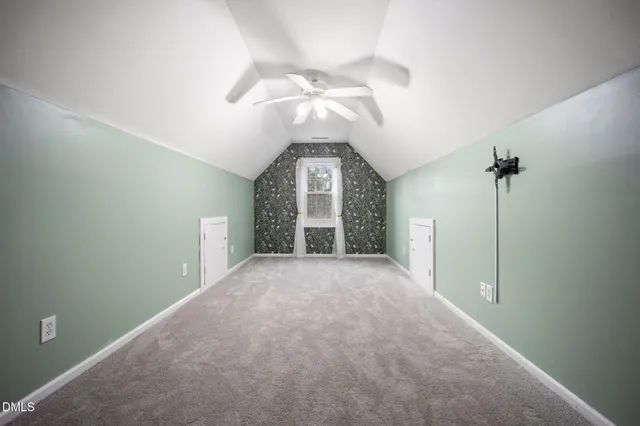 a view of a hallway with a chandelier fan and windows