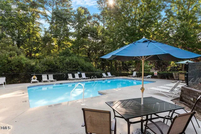 a wooden table and chair under an umbrella