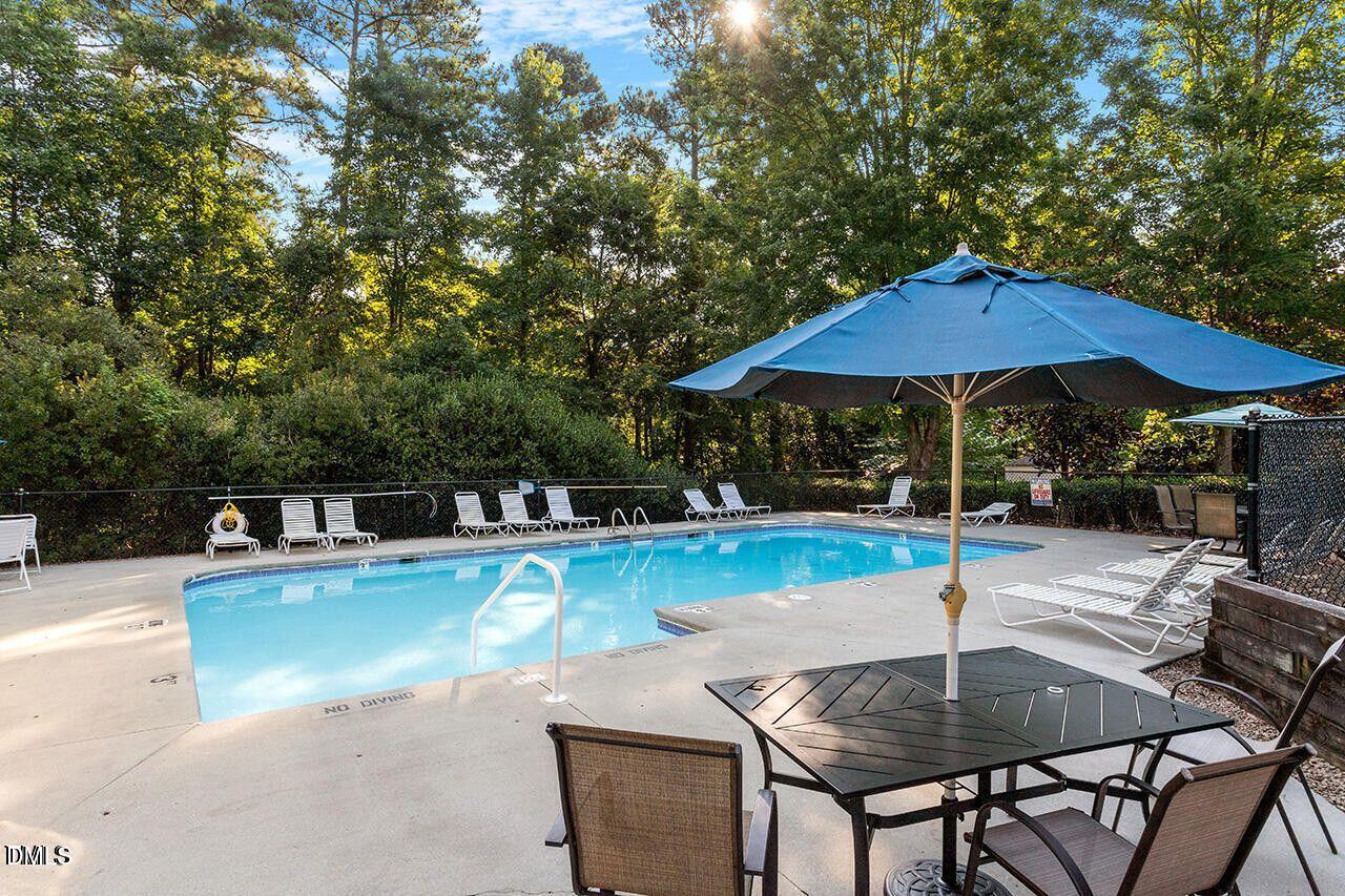 8665 Harps Mill Road Raleigh, NC 27615 - Photo 36 of 36 a wooden table and chair under an umbrella