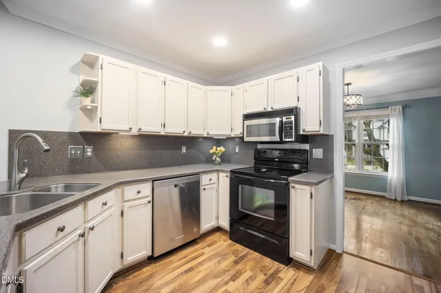 a kitchen with granite countertop a stove sink and microwave