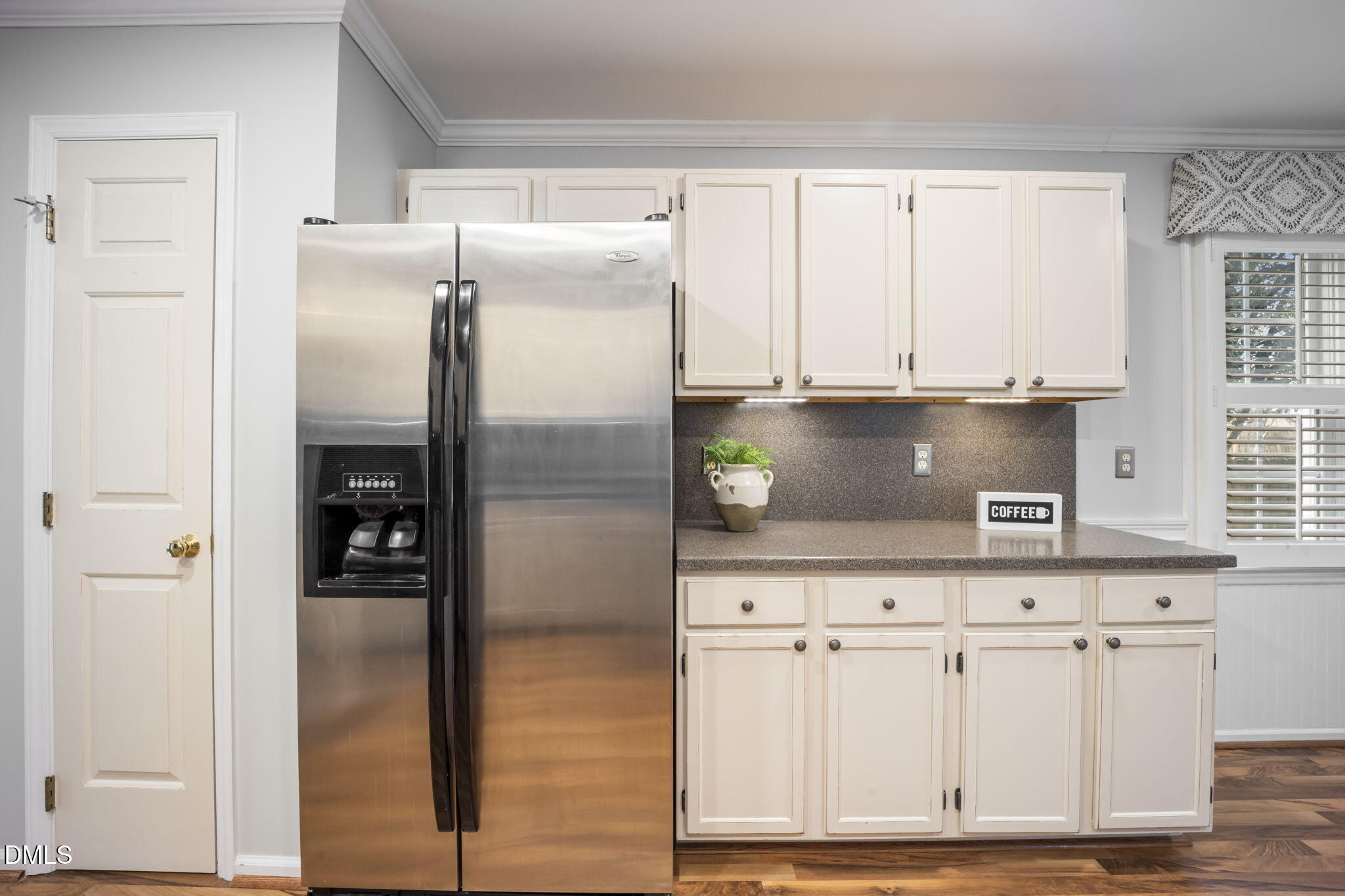 8665 Harps Mill Road Raleigh, NC 27615 - Photo 9 of 36 a kitchen with white cabinets and refrigerator