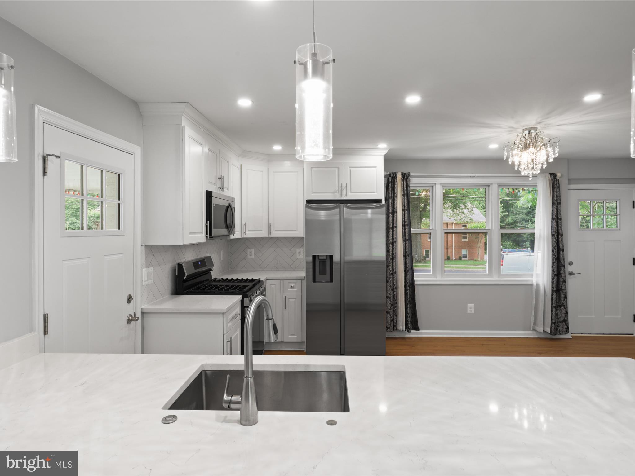 7435 Bath Street Springfield, VA 22150 - Photo 12 of 28 a kitchen with stainless steel appliances kitchen island granite countertop a refrigerator and a sink