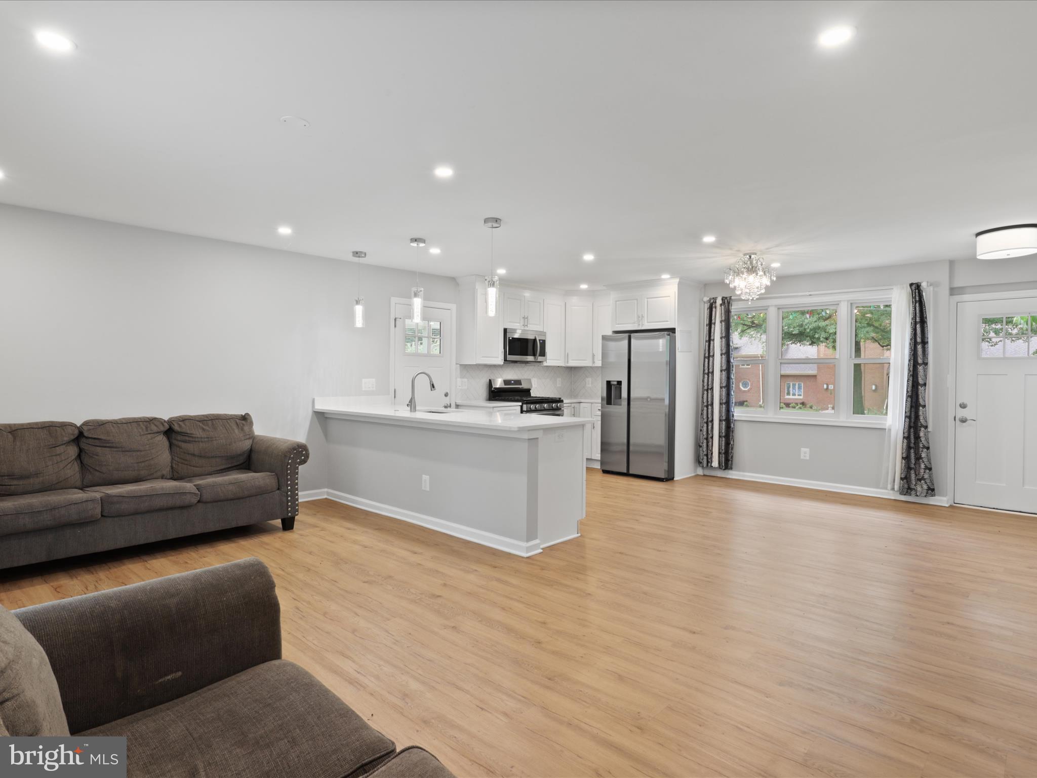 7435 Bath Street Springfield, VA 22150 - Photo 15 of 28 a living room with stainless steel appliances kitchen island granite countertop a couch and a view of kitchen