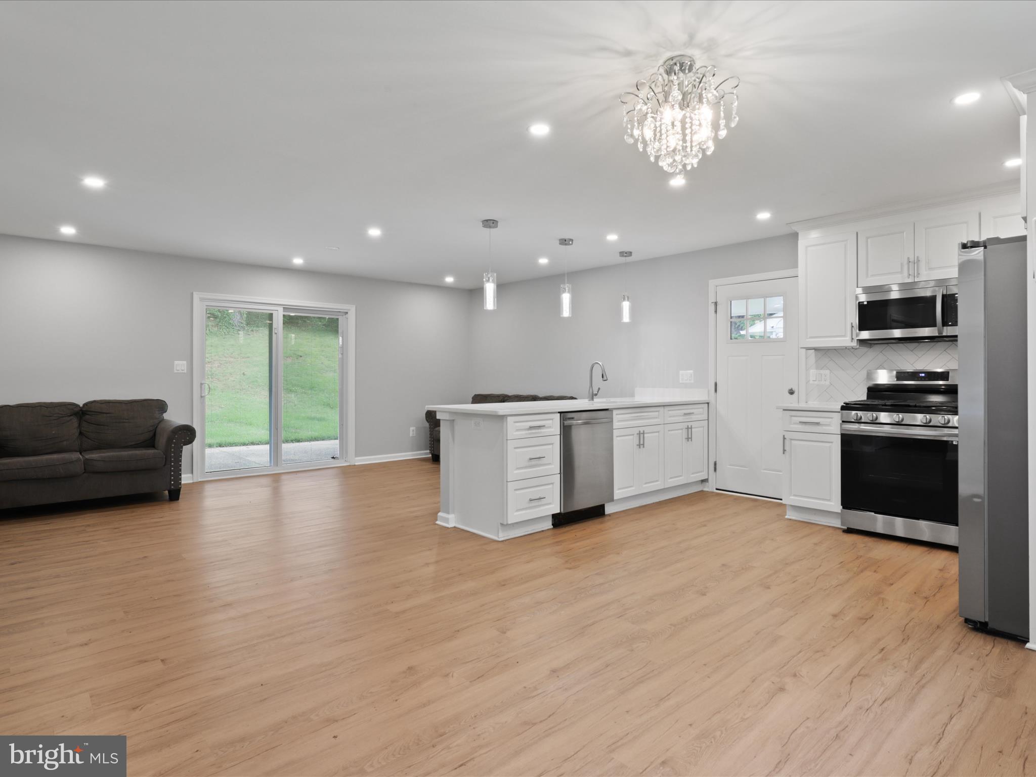7435 Bath Street Springfield, VA 22150 - Photo 9 of 28 a view of kitchen with stainless steel appliances granite countertop a stove top oven a sink dishwasher a dining table and chairs with wooden floor