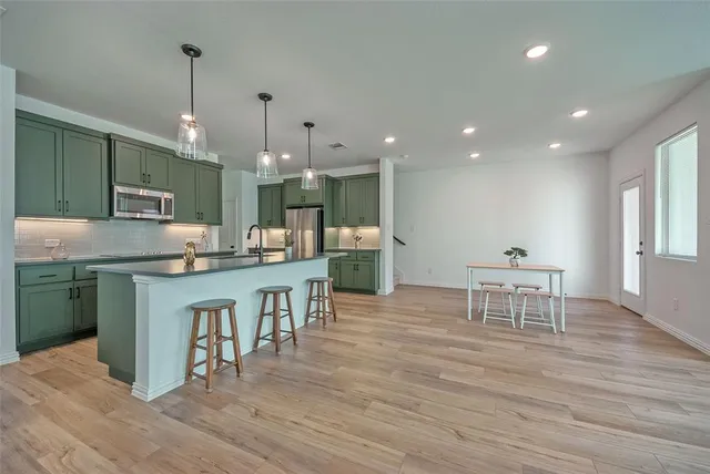 a kitchen with kitchen island granite countertop a sink cabinets and wooden floor
