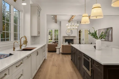 a living room with furniture a large window and a chandelier