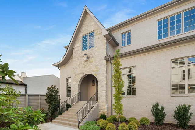 a view of white house with a yard and potted plants
