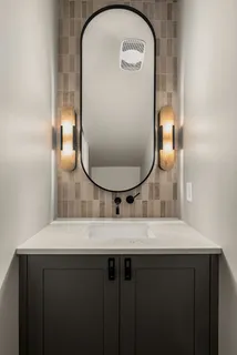 a bathroom with a tub a sink and a large mirror