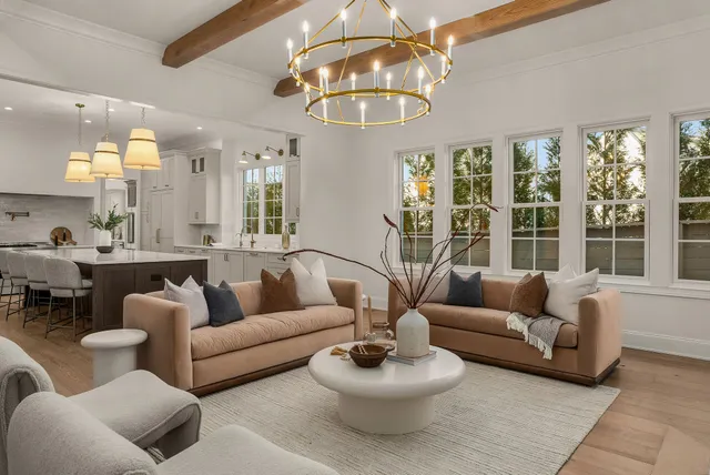 a kitchen with stainless steel appliances granite countertop a stove a chimney a sink and a dining table with garden view