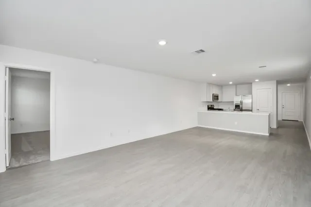 a view of a kitchen with white cabinets and wooden floor