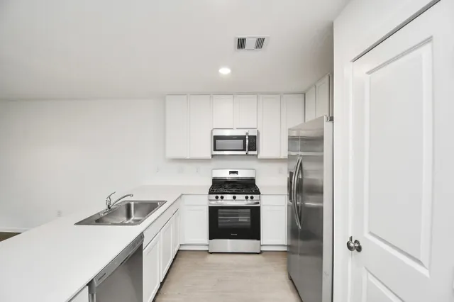 a kitchen with a sink a stove and refrigerator