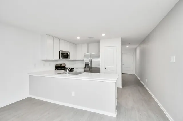 a kitchen with stainless steel appliances a refrigerator sink and microwave