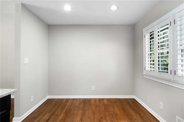 a view of a room with wooden floor and small window