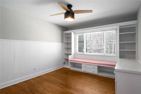 an empty room with wooden floor and windows