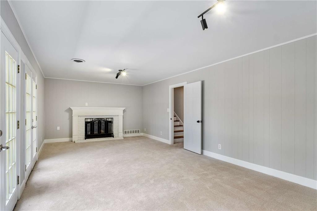 3240 Pinestream Road Northwest Atlanta, GA 30327 - Photo 29 of 42 a view of an empty room with a fireplace and a window