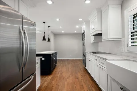a kitchen with stainless steel appliances a refrigerator sink and stove