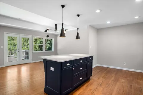 a kitchen with a stove and a wooden floor