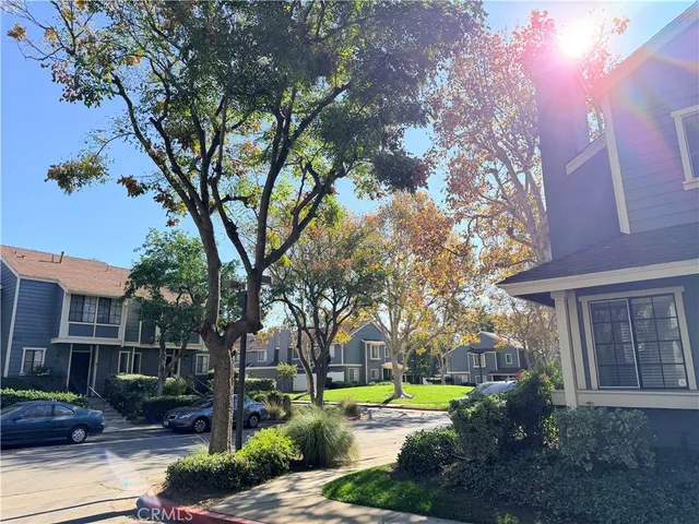 a view of a house with a yard and large trees