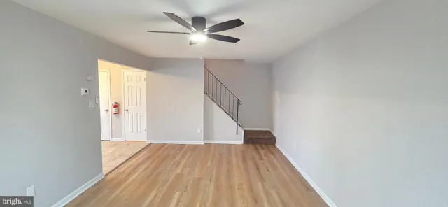 a view of a hallway with wooden floor and staircase