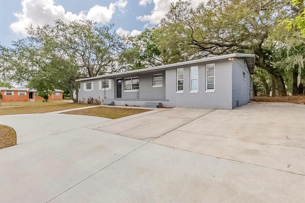 5500 Riviera Drive Orlando, FL 32808 - Photo 2 of 48 a backyard of a house with yard and large trees
