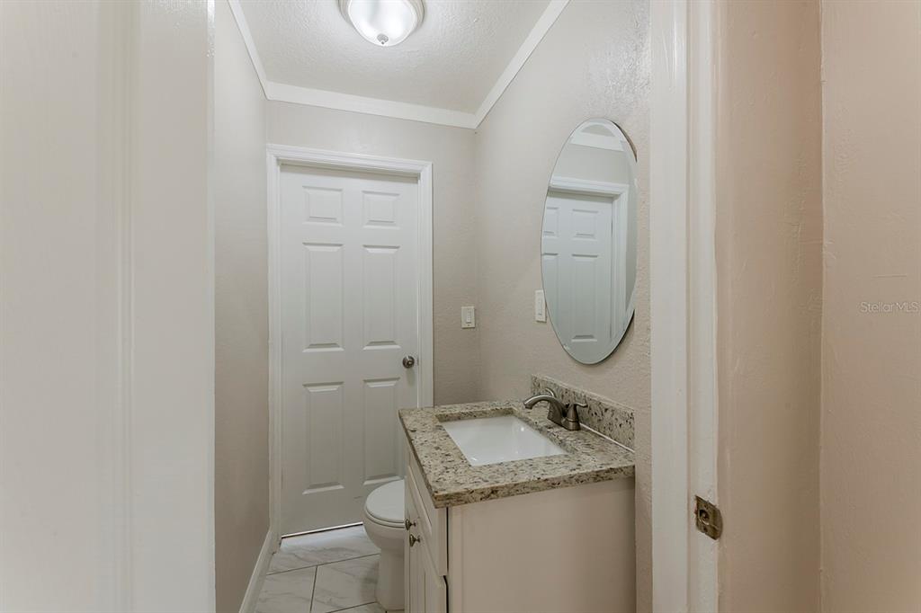 5500 Riviera Drive Orlando, FL 32808 - Photo 25 of 48 a bathroom with a granite countertop sink a toilet and a mirror