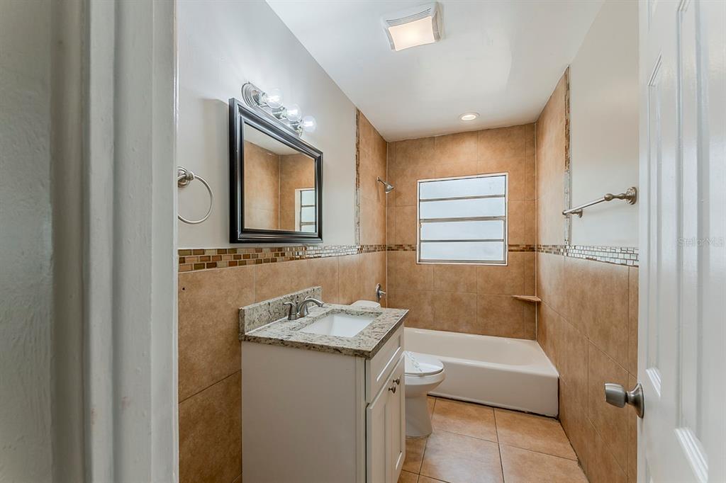 5500 Riviera Drive Orlando, FL 32808 - Photo 32 of 48 a bathroom with a granite countertop sink and a mirror