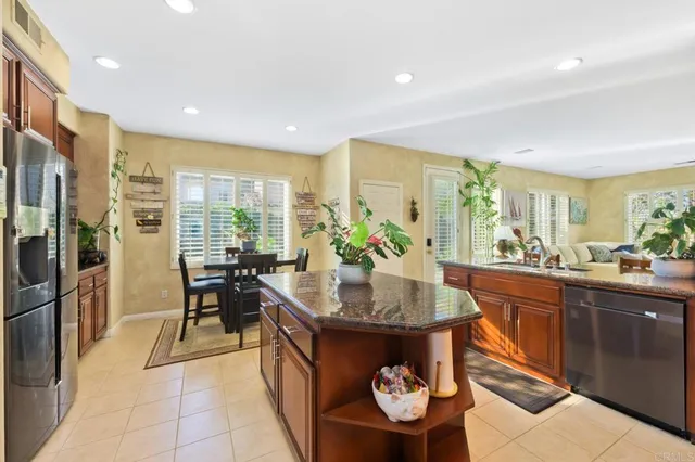 a kitchen with stainless steel appliances granite countertop a stove refrigerator sink and cabinets