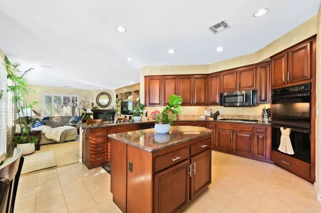 a kitchen with granite countertop a refrigerator and a stove top oven