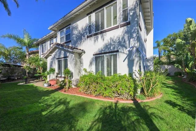 a view of a house with a yard and potted plants