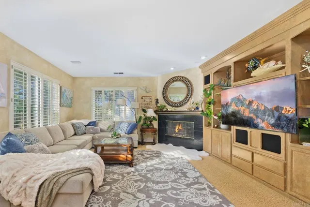 a living room with furniture a fireplace and a flat screen tv