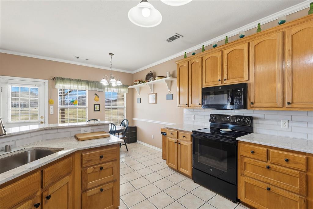 9920 County Road 540 Lavon, TX 75166 - Photo 11 of 32 a kitchen with stainless steel appliances granite countertop a sink a stove and a refrigerator