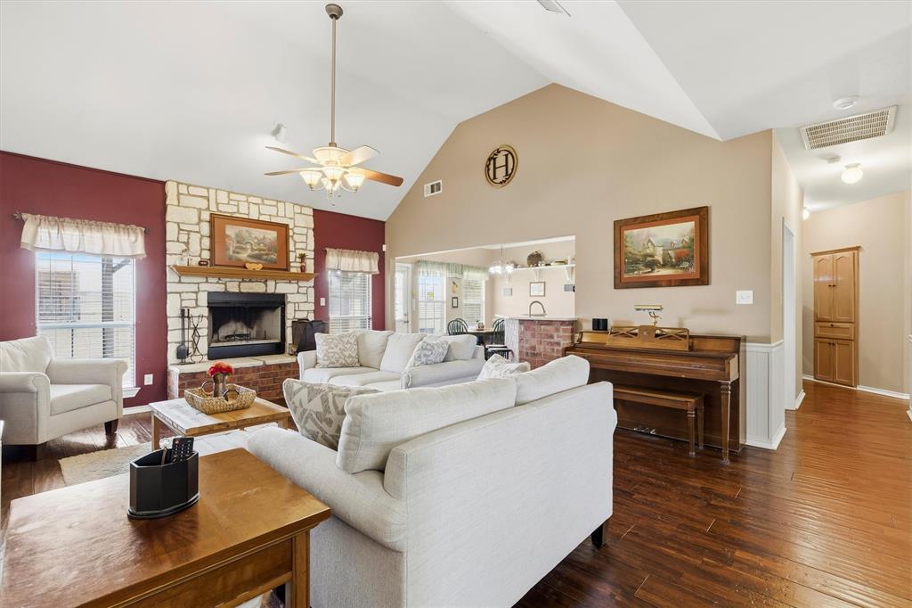 9920 County Road 540 Lavon, TX 75166 - Photo 6 of 32 a living room with couches a fireplace and kitchen view with wooden floor